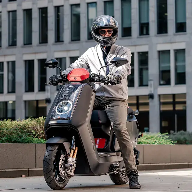 Man with helmet on sits on the new NQiX 1000 motorcycle from NIU , © NIU