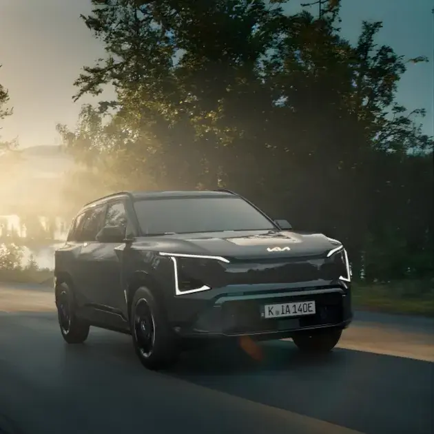 Kia EV5 electric SUV featuring a modern design with LED lighting signature, bold lines and a sleek silhouette, shown in an urban setting.